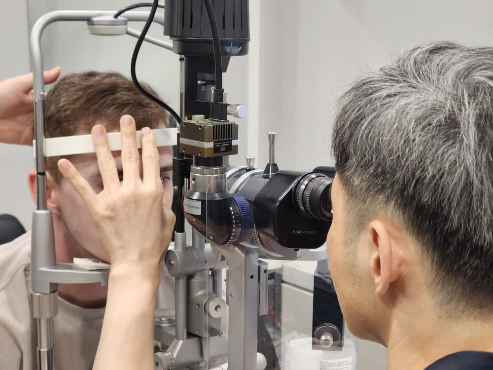 Ophthalmologist at Samsung Miracle Eye Clinic explaining vision analysis to a patient using diagnostic imaging tools in Gangnam, Korea